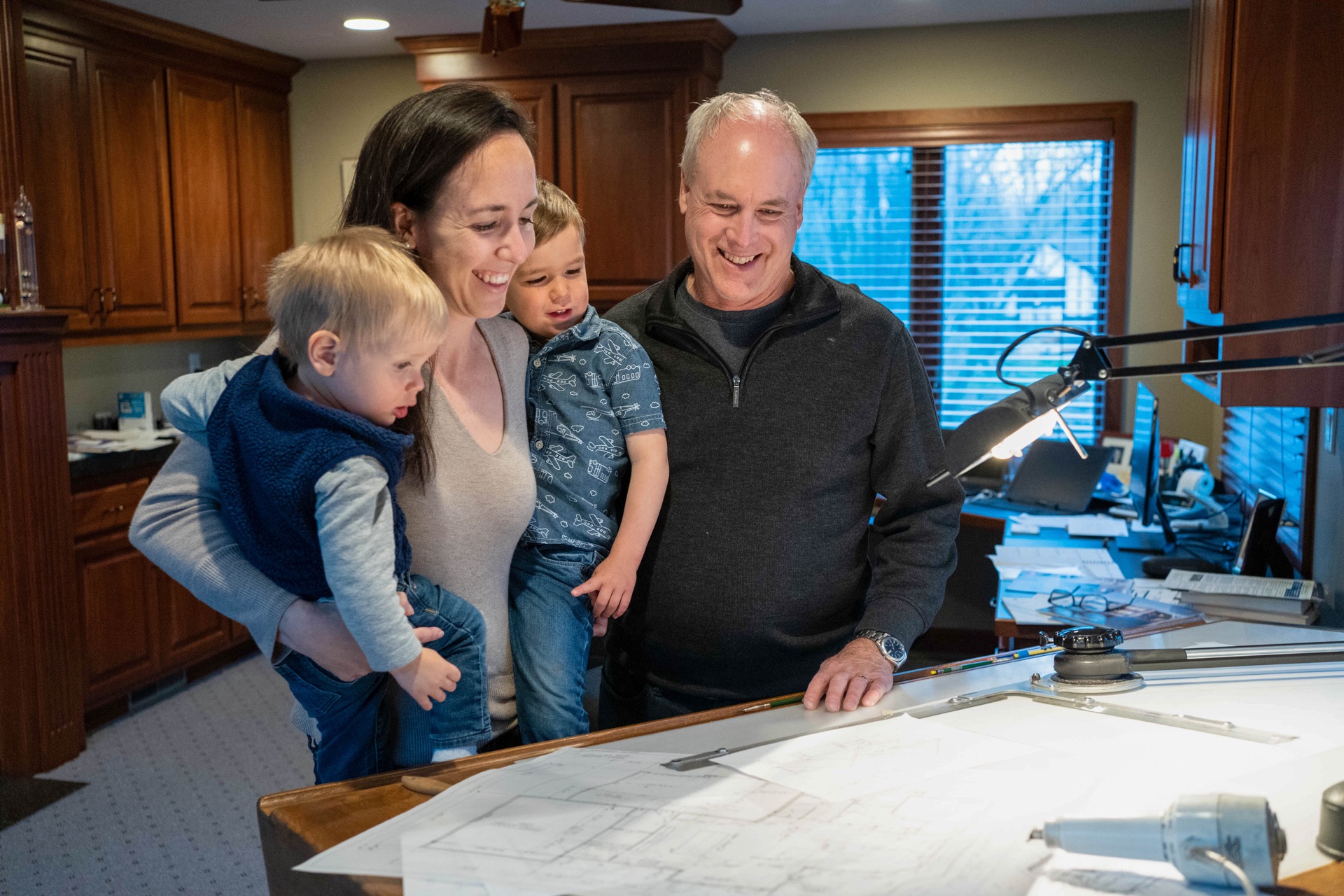 Family reviewing custom home blueprints with builder JC Peterson in Plymouth MN