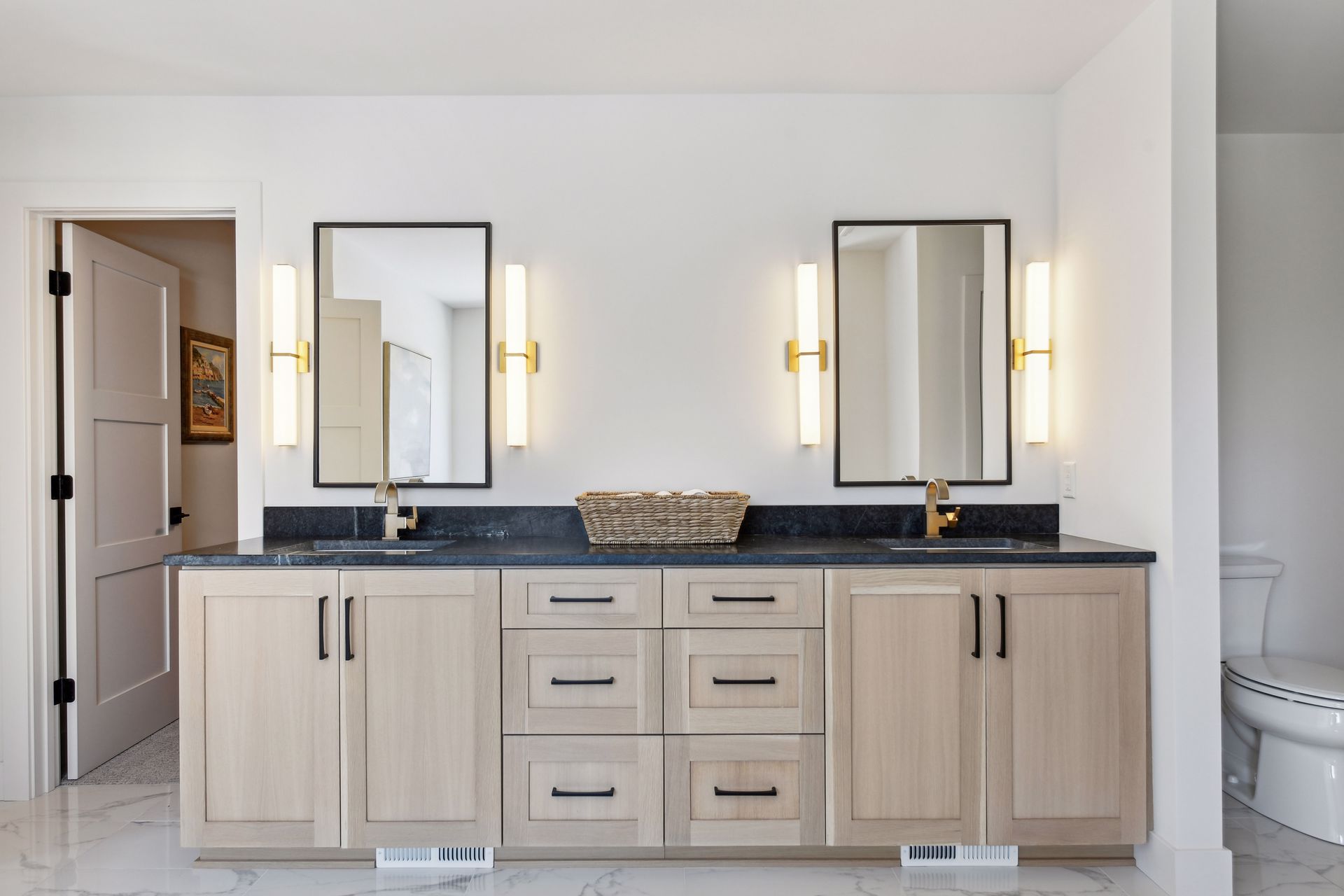 Master bath with double vanity, soapstone countertop and brass sconces